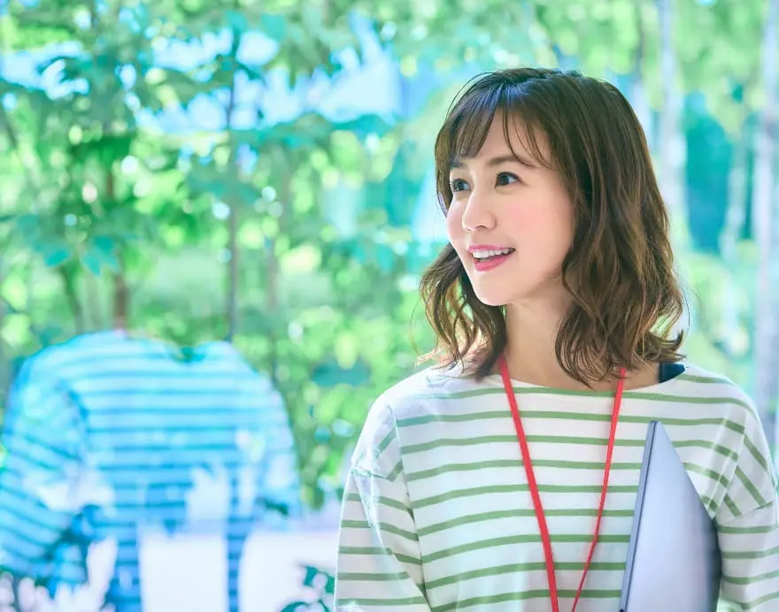 ノートパソコンを抱えている女性の写真