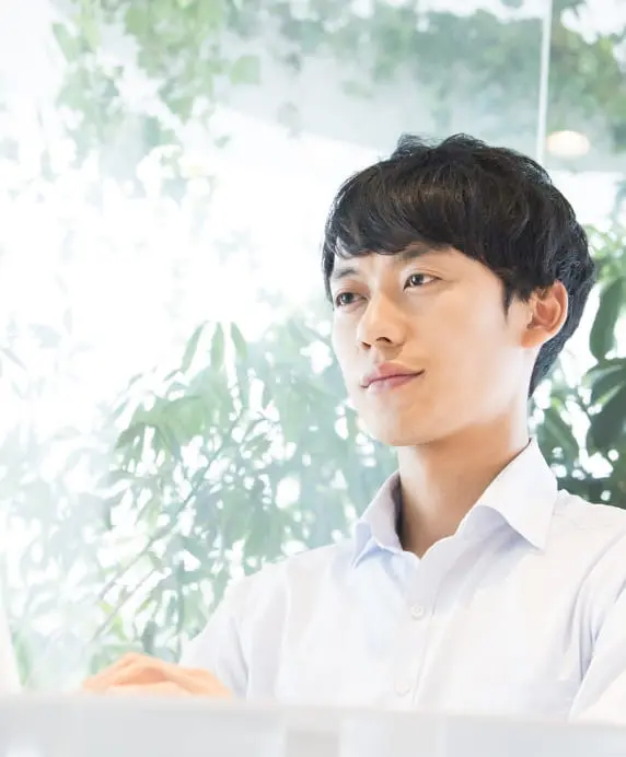 自然光の差し込む室内でパソコンを操作する男性