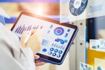 タブレットを使って業務データを分析するビジネスパーソン。グラフやチャートを活用し生産性向上に取り組んでいる