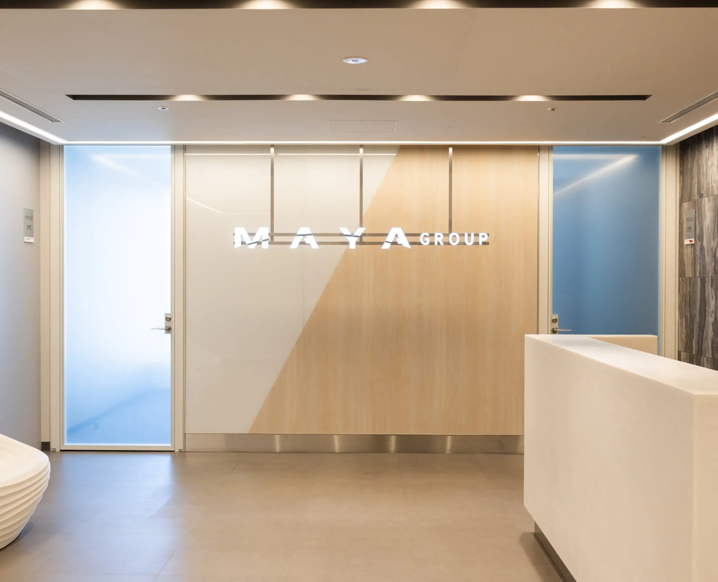 企業の受付ロビー。MAYA GROUPのロゴが壁に掲げられている写真